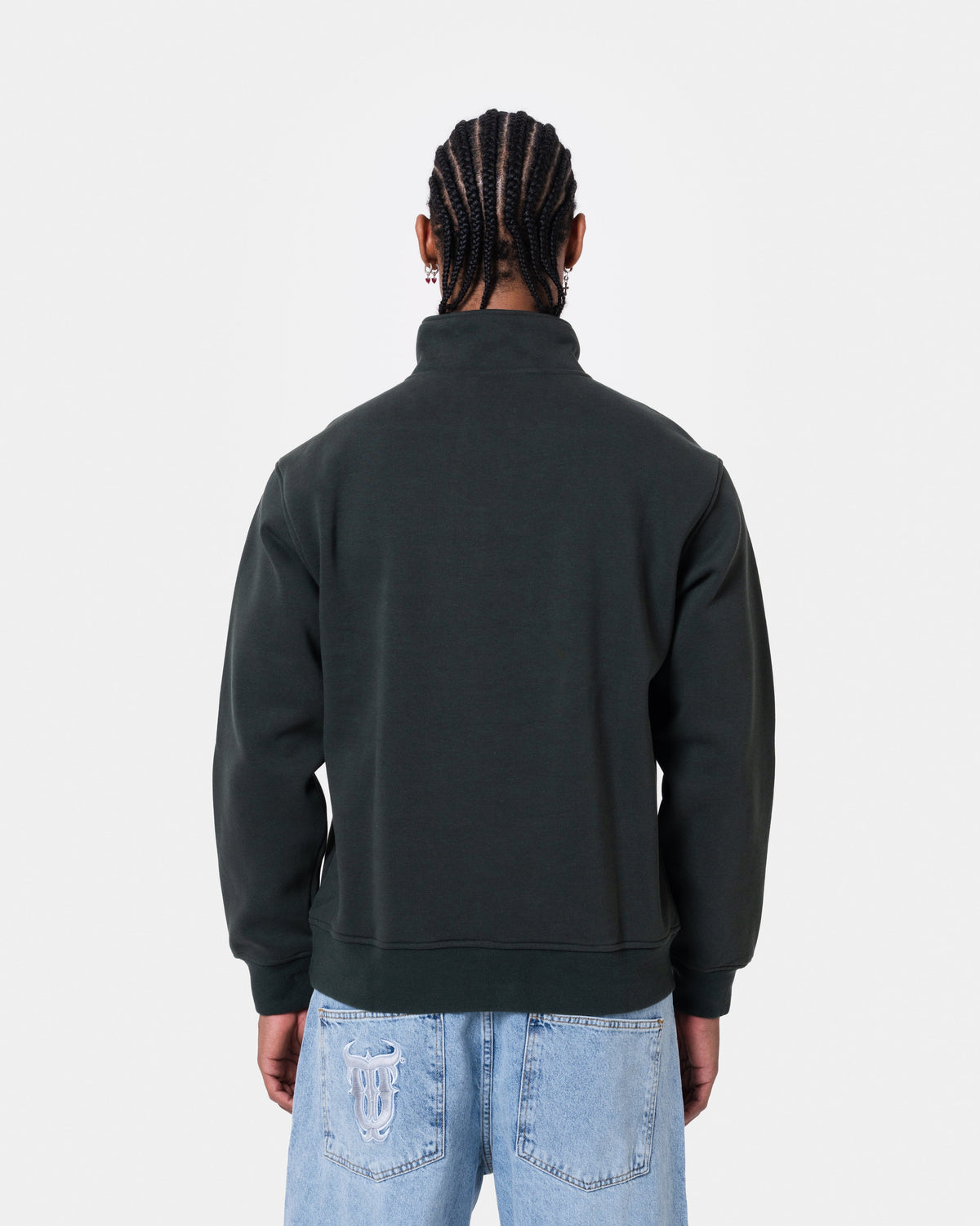 Back view of a man wearing FAT QUNTO HALFZIP BLACK, a loose fit short zipper sweatshirt in black.