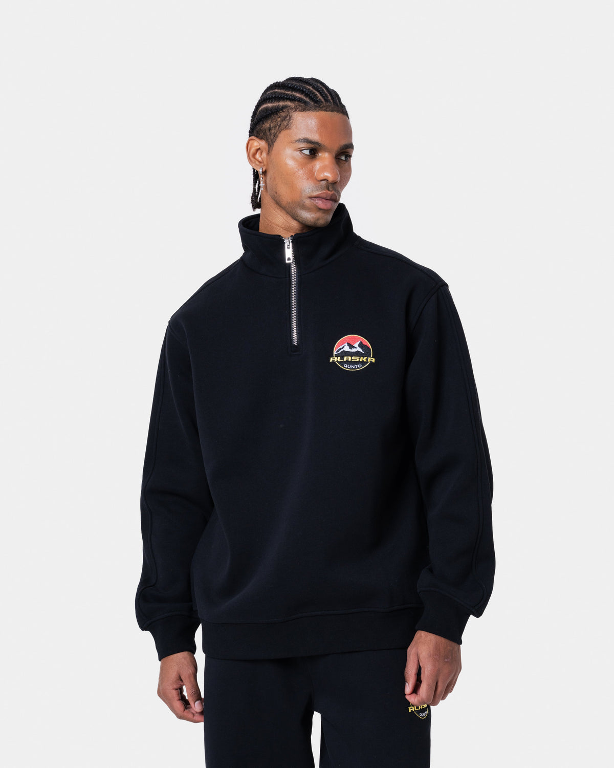 Model wearing ALASKA BADGE BLACK HALFZIP sweatshirt, black color, loose fit, short zipper, high quality fabric.