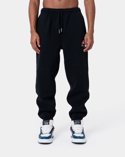 ALASKA BADGE BLACK JOGGER displayed on model, featuring loose fit, side and back pockets, elastic waistband.