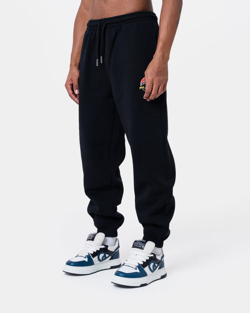 ALASKA BADGE BLACK JOGGER on model, featuring a loose fit, side pockets, and elastic waistbands, perfect for comfort.