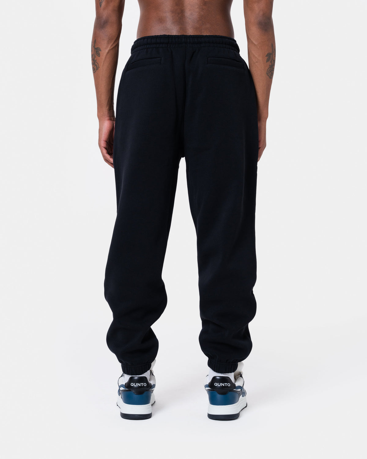 Man wearing ALASKA BADGE BLACK JOGGER with back pockets and elastic waistbands in black color.